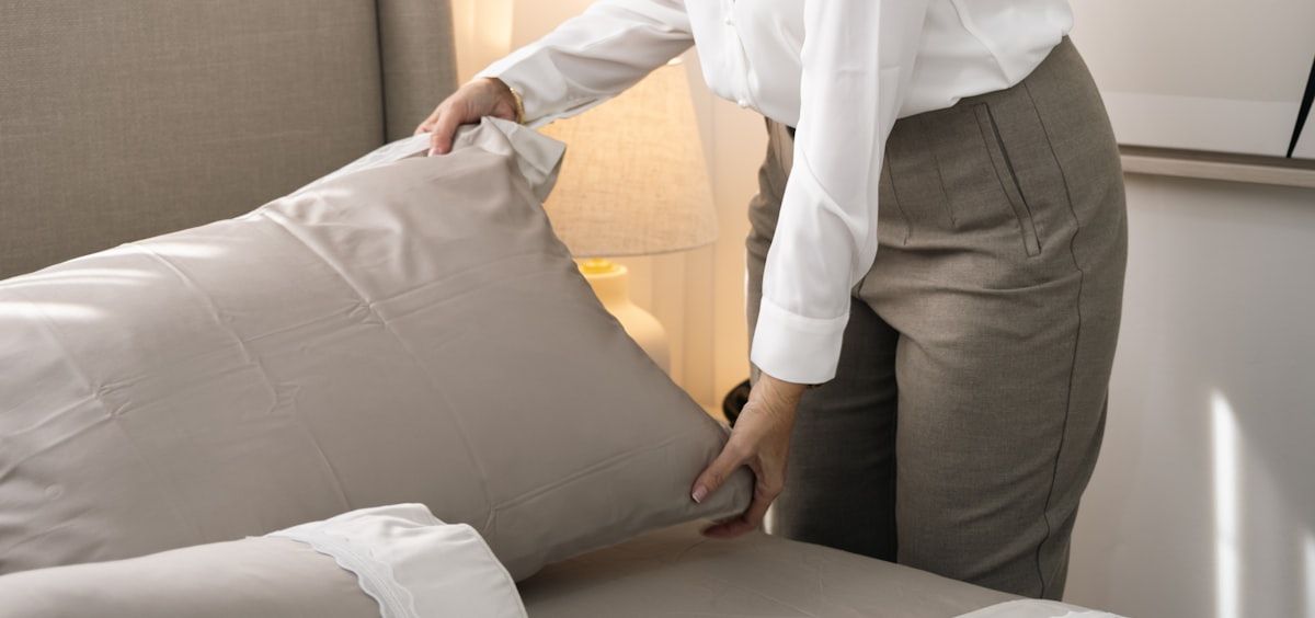 A woman straightening a cushion while turning a room around